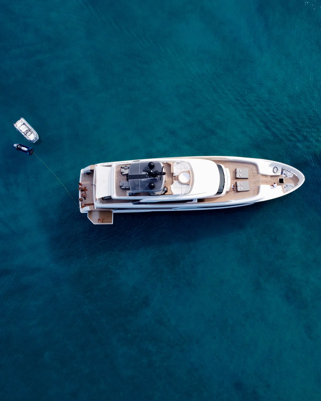 Aerial view of a superyacht anchored in clear turquoise water